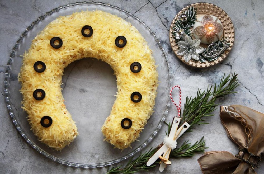 Салат на блюде возле новогоднего декора