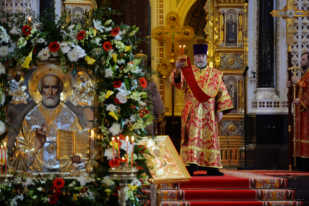 Икона на фоне священника